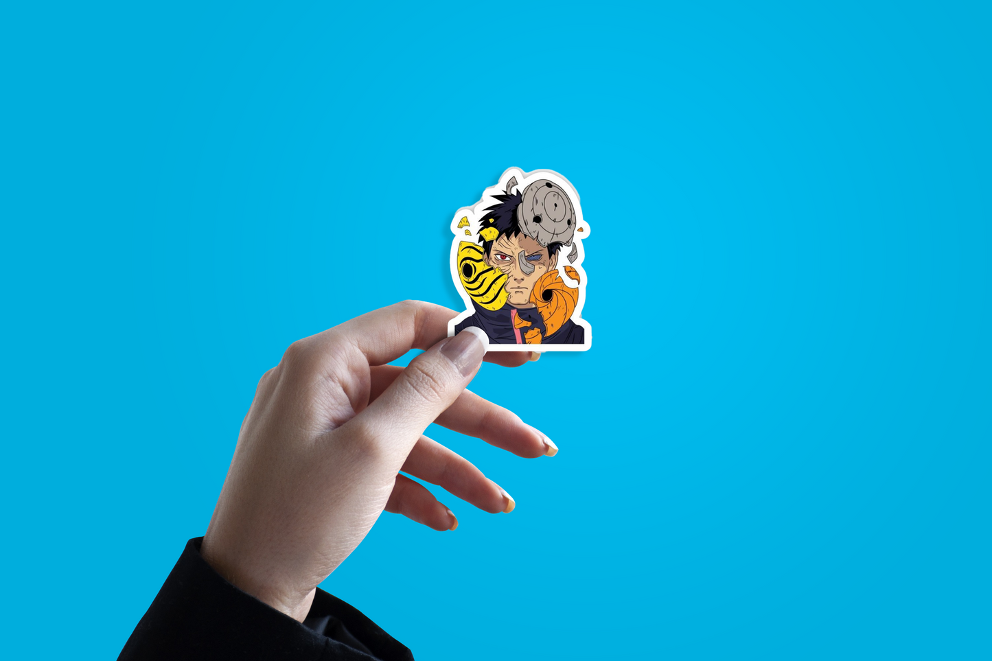 Hand holding a sticker of an animated character against a blue background