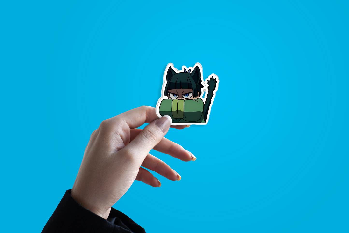 Hand holding a sticker of an animated character against a blue background