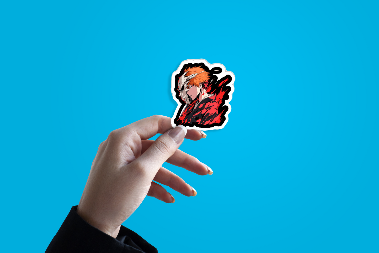 Hand holding a sticker with a red and black design against a blue background
